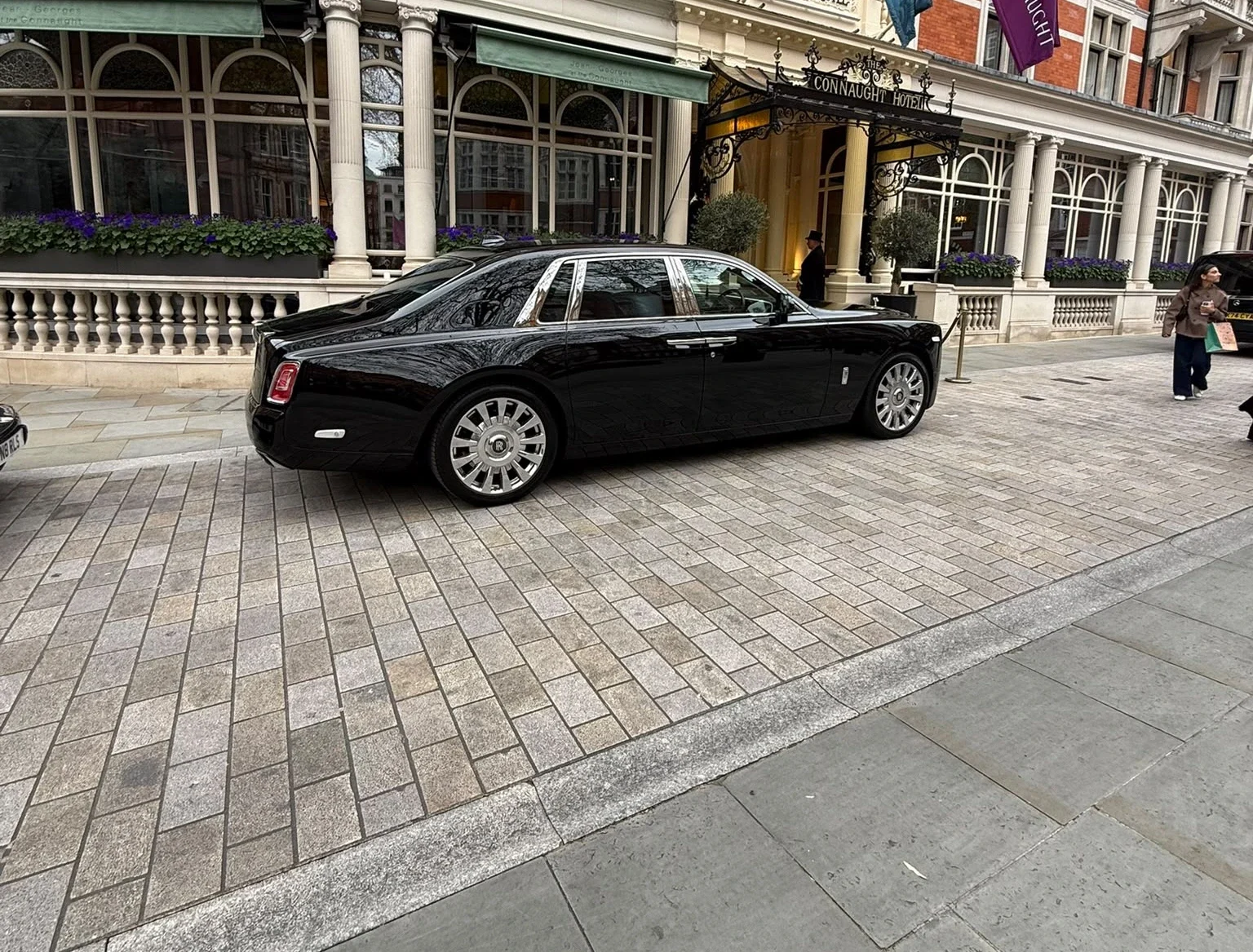 Rolls-Royce Phantom VIII luxury chauffeur vehicle outside The Connaught Hotel entrance in Mayfair London