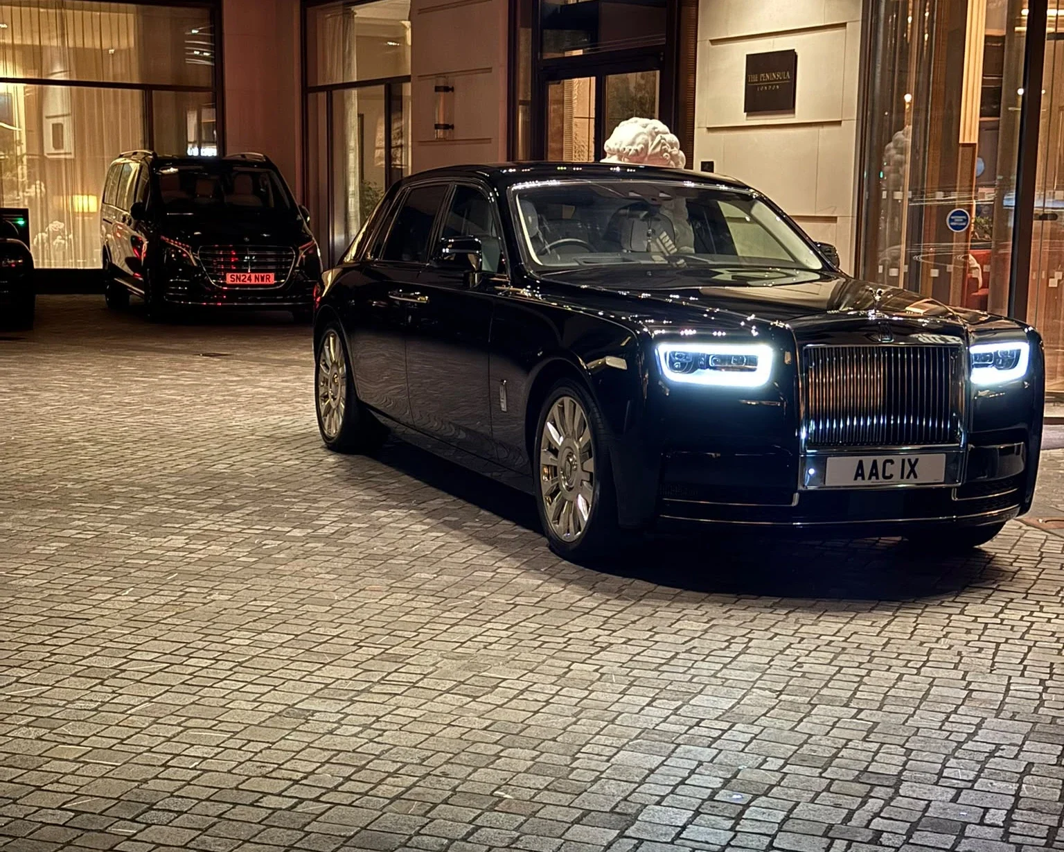 Rolls-Royce Phantom and Mercedes V-Class luxury chauffeur vehicles at The Peninsula London forecourt